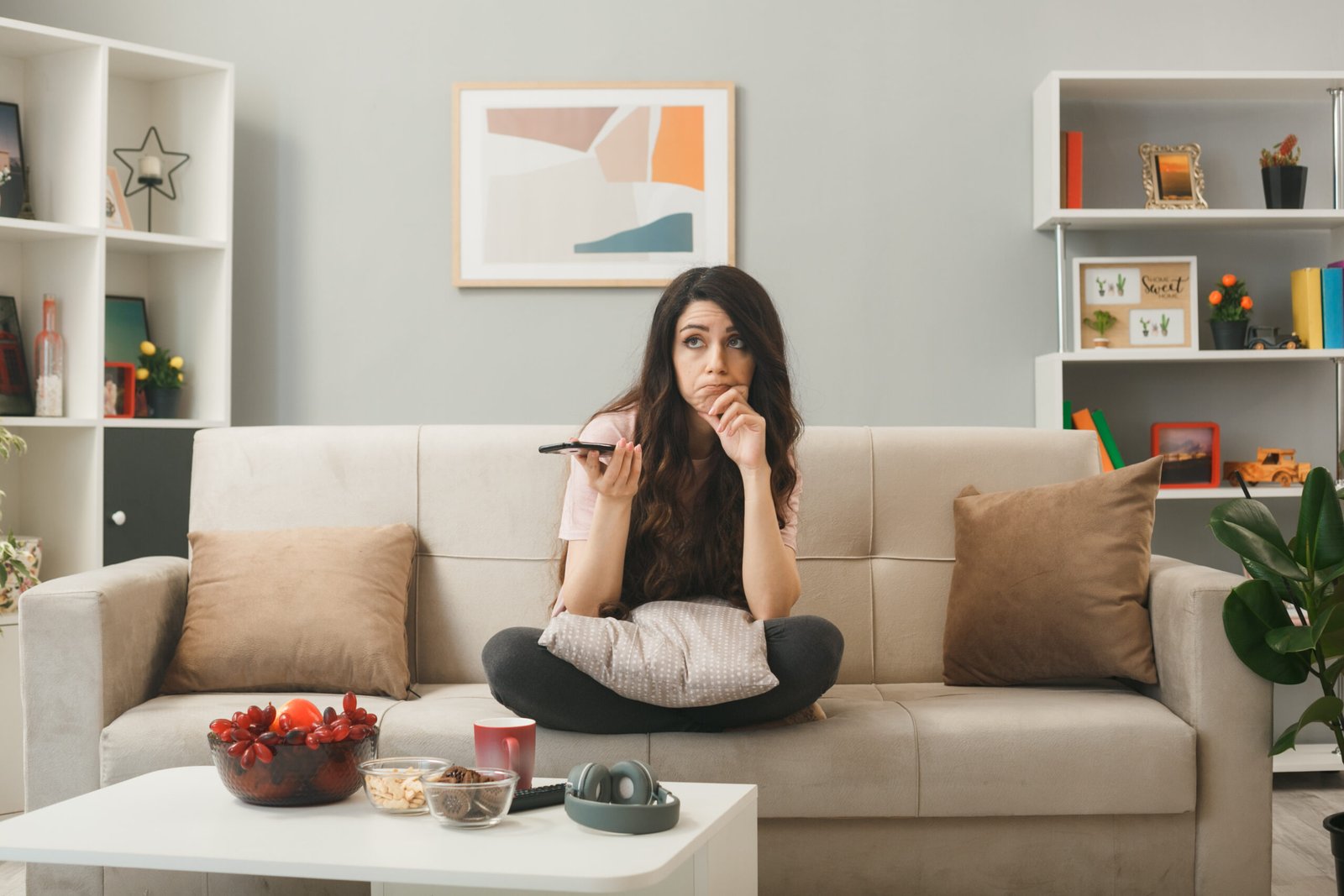 Woman using a phone while sitting on a sofa